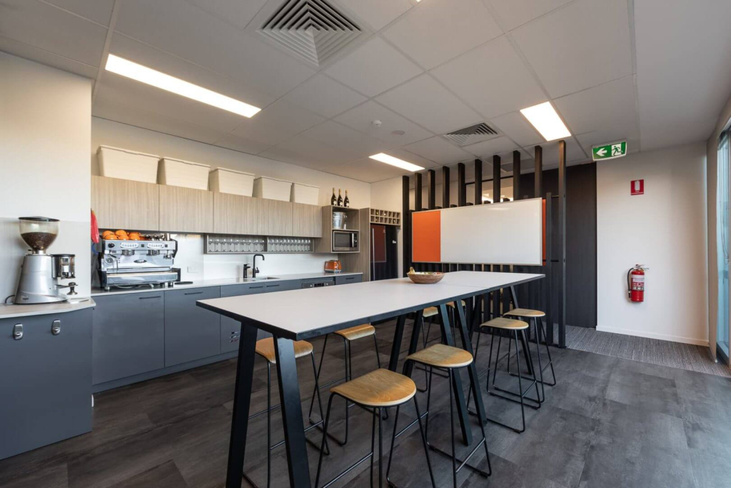 Office kitchen and coffee lounge with a communal seating area, fostering social interactions and casual meetings among coworkers.