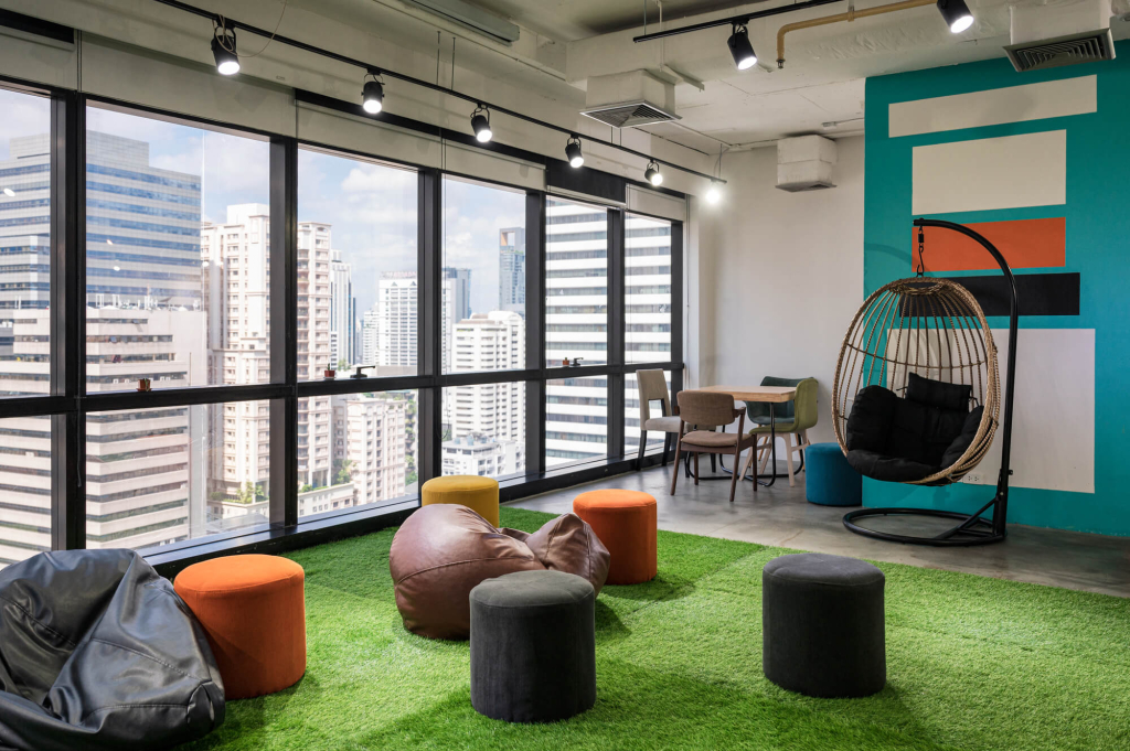 Bright coworking space with biophilic design elements, including greenery and ample natural light, promoting a collaborative environment.