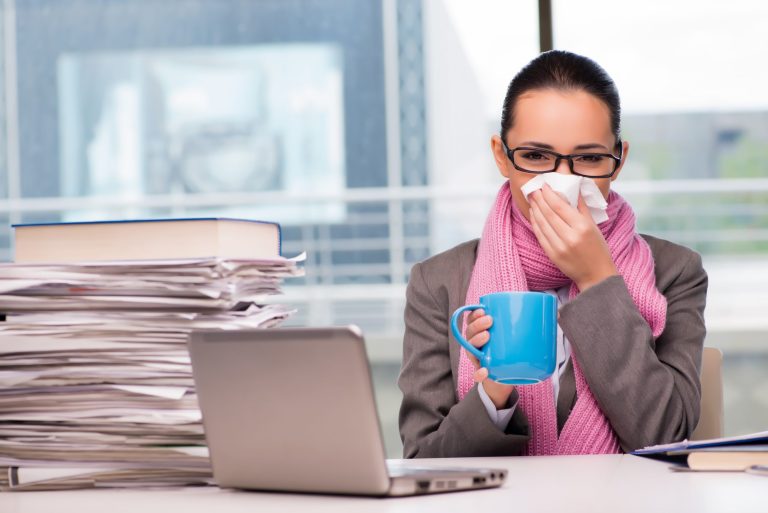 Young businesswoman sick in the office