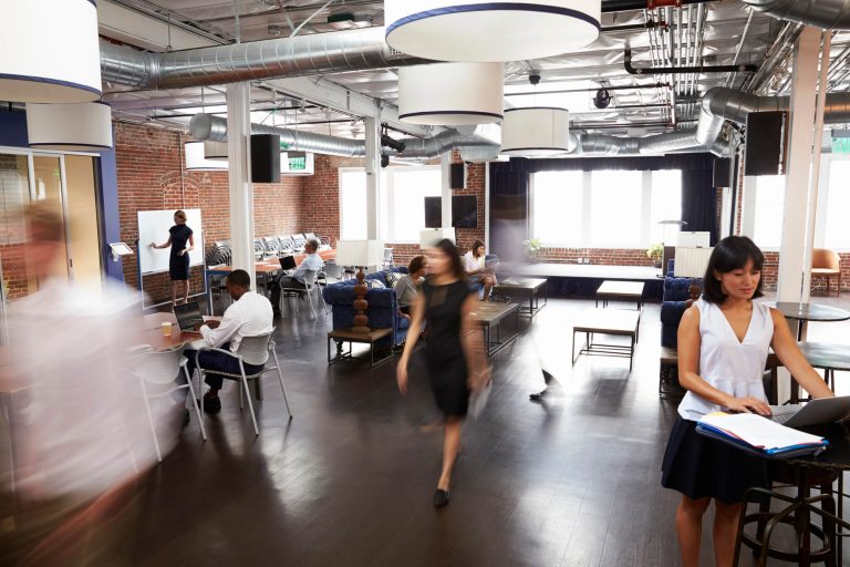 Industrial-style coworking space featuring an open layout with flexible event space, meeting areas, and ample natural light to encourage collaboration.